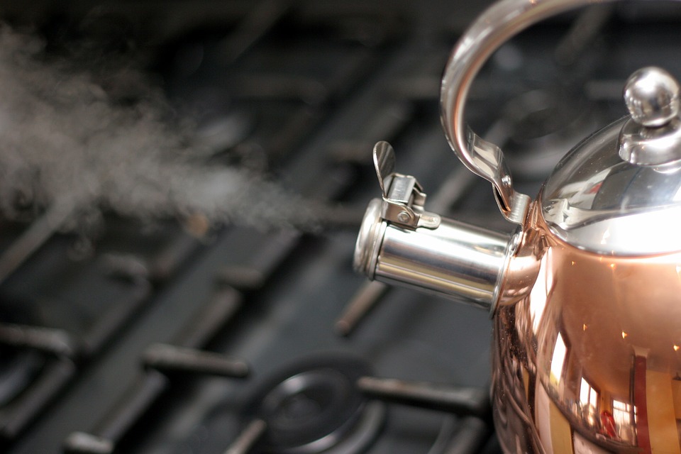 蒸汽从铜茶壶出来。