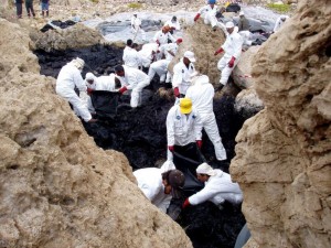 Hazmat诉讼的人们清理沿海漏油泄漏。